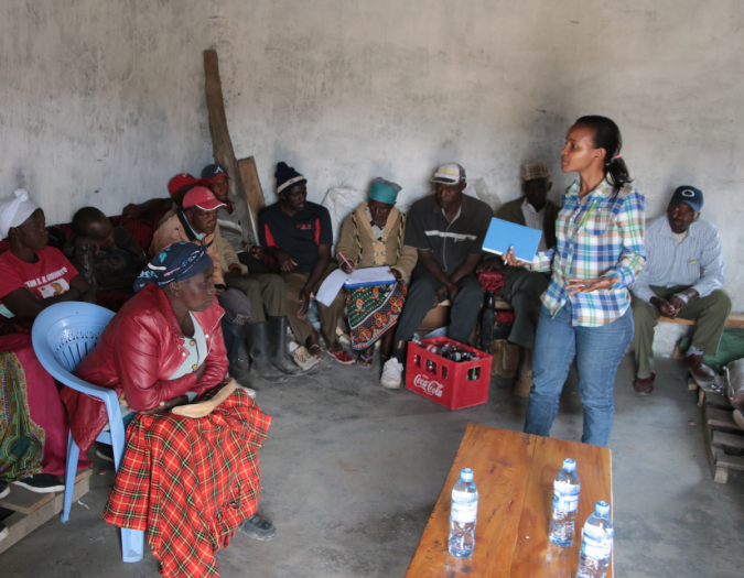 a woman leads a discussion with farmers