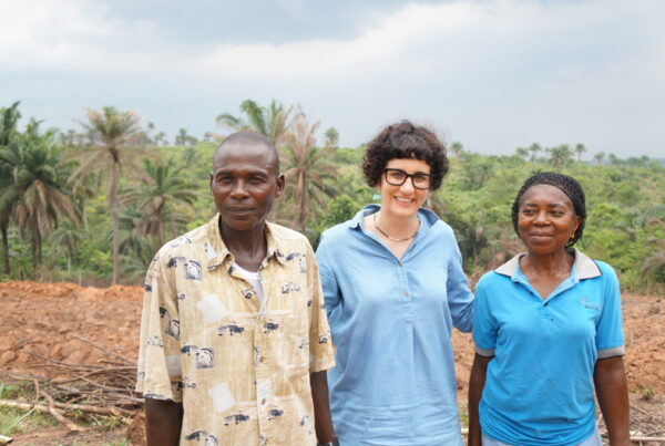 two cassava farmers stand next to Dr. Tufan