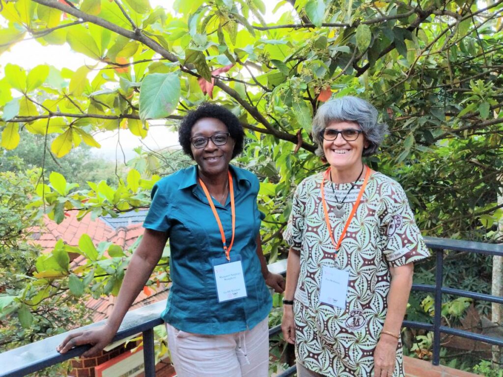 two women pose on a scenic balcony