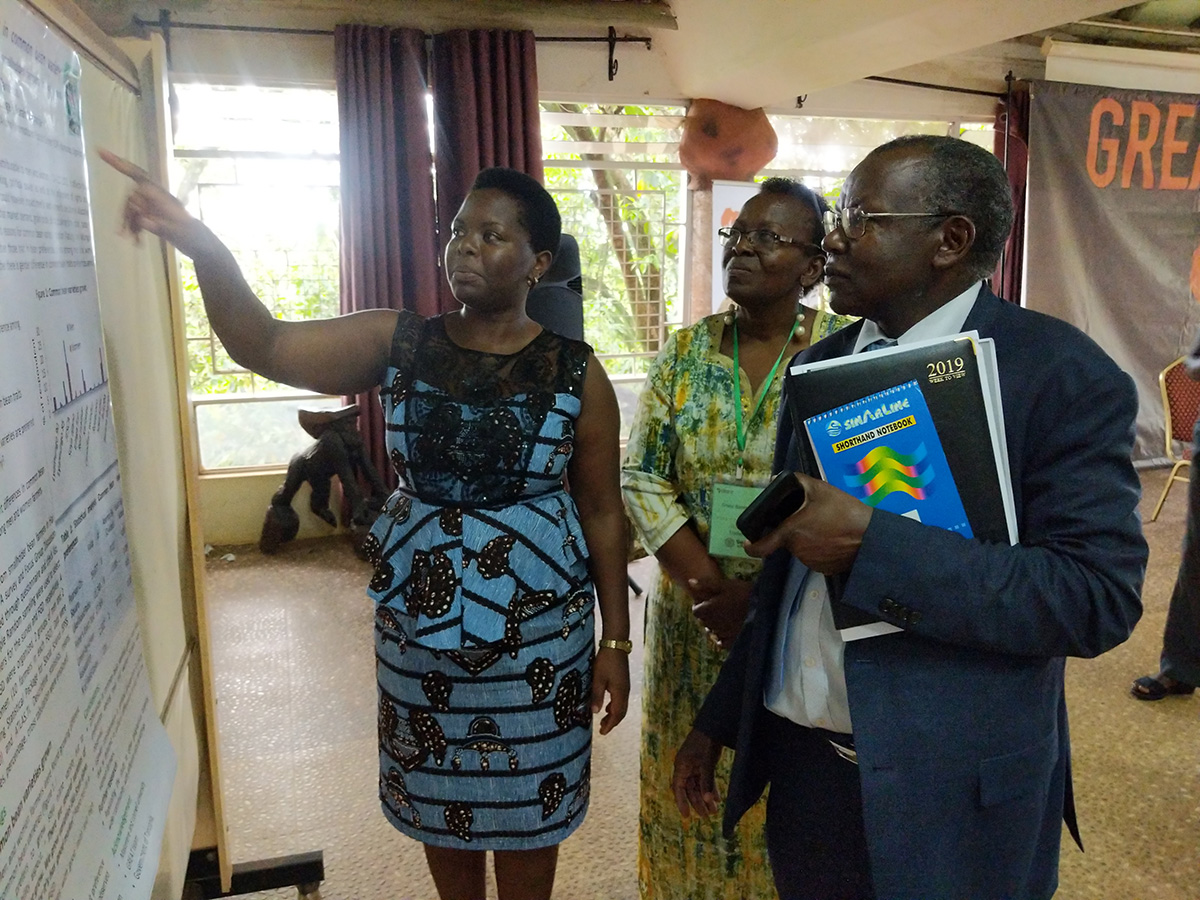 A scientist points to a poster while others listen